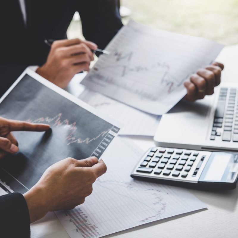 Business team colleagues working with computer, laptop, discussing and analysis graph stock market trading with stock chart data, financial and investment concept.