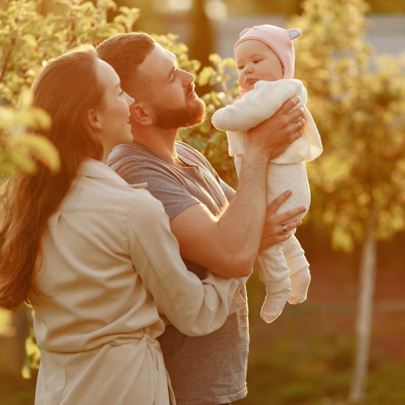 Parents with daughter. Family in a park. Newborn girl.