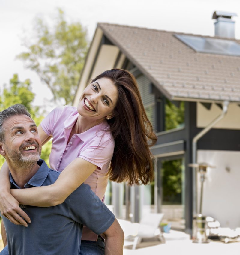 Portrait of happy couple in garden of their home